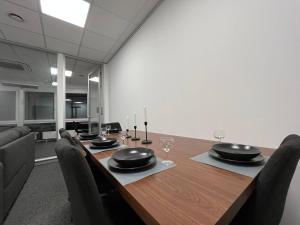 a dining room with a table with chairs and glasses at Simplex Apartments Am Schwabentorring in Freiburg im Breisgau