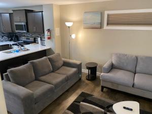sala de estar con sofá y cocina en Harbour landing home with 2 living rooms, King bed and 2 car garage, en Regina