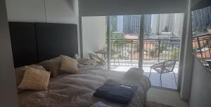 a bed in a room with a view of a balcony at Darren Surfers Apartment in Gold Coast