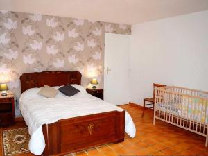 a bedroom with a bed and a baby crib at Gîte familial en Touraine avec jardin, proche châteaux et vignobles, animaux acceptés. - FR-1-381-240 in Mazières-de-Touraine