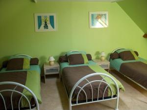 2 łóżka w pokoju z zielonymi ścianami w obiekcie Gîte Saint-Omer, 4 pièces, 7 personnes - FR-1-376-72 w mieście Saint-Omer