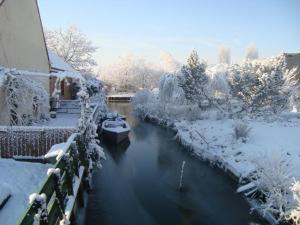 a river covered in snow next to a building at Gîte Saint-Omer, 4 pièces, 7 personnes - FR-1-376-72 in Saint-Omer