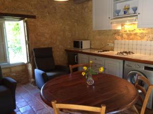 a kitchen with a wooden table in a kitchen with a table at Séjour Authentique au Pigeonnier avec Wifi et Parking - FR-1-616-101 in Monsac +5 photos