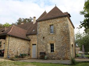 una antigua casa de piedra con techo marrón en Gîte Monsac, 4 pièces, 6 personnes - FR-1-616-118, en Monsac