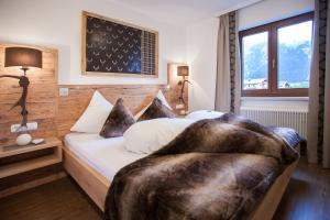 a hotel room with a bed with a large blanket at Alpenherz Ferienwohnungen in Pertisau
