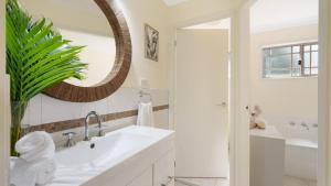 a white bathroom with a sink and a mirror at Bombo Blue in Kiama +20 photos