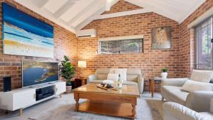 a living room with a brick wall at Bombo Blue in Kiama