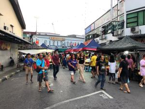 een groep mensen die door een straatmarkt lopen bij City hotel in Sibu