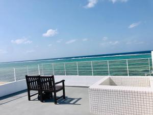a bench sitting on a balcony looking at the ocean at CASA DUMAI OceanVilla NAKIJIN in Nakijin +43 photos
