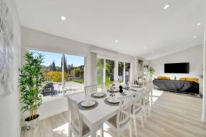 uma sala de jantar branca com uma mesa e cadeiras brancas em New! King Suite House with an Amazing Valley View! em Los Angeles