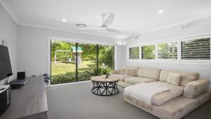 a living room with a couch and a table at Paradise in Pearl-walk to beach, ducted air in Pearl Beach