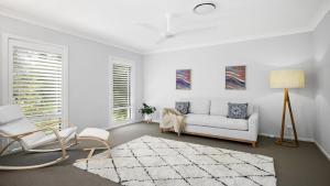 a white living room with a couch and chairs at Paradise in Pearl-walk to beach, ducted air in Pearl Beach +15 photos