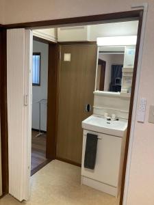 a bathroom with a sink and a mirror at 梅屋敷貸戸建 in Tokyo