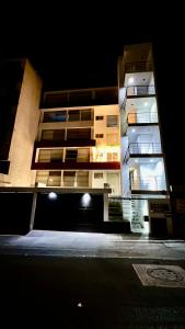 un palazzo alto di notte con le luci accese di Amplia Habitación Privada en Alojamiento Compartido por Plaza San Luis a San Luis Potosí