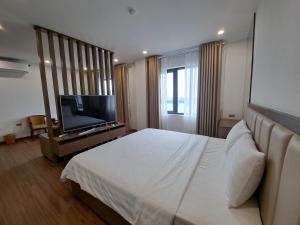 a bedroom with a bed and a flat screen tv at Glory Hotel Apartment Hải Phòng in Hai Phong
