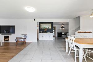 a kitchen and living room with a table and a television at Unwind on Prince in Urangan