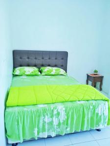1 cama con edredón verde y mesa en HOTEL ANANDA, 