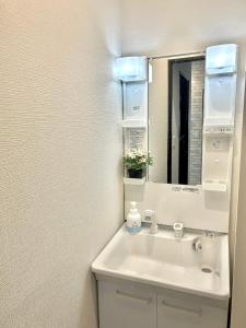 uma casa de banho com um lavatório e um espelho em 東京 足立区青井 Tokyo Adachiku Aoi em Tóquio