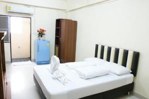 a room with a bed with white pillows at Kim Hotel At Bangplong in Ban Bang Prong