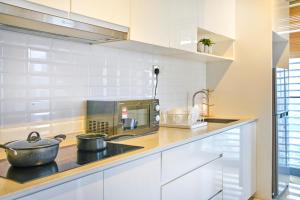 a kitchen with white cabinets and a pot on the stove at Continew Residence TRX KL in Kuala Lumpur