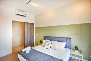 a bedroom with a bed with a blue headboard at Continew Residence TRX KL in Kuala Lumpur