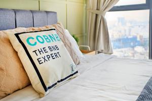 a bed with a pillow that says come the bug expert at Continew Residence TRX KL in Kuala Lumpur