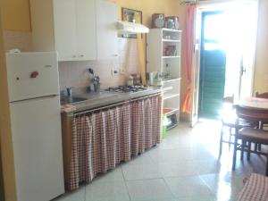 ジャルディーニ・ナクソスにあるAppartamento Glass Cinquecentoのキッチン(白い冷蔵庫、シンク付)