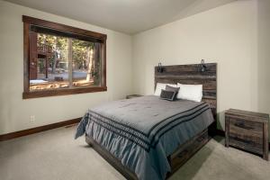 a bedroom with a bed and a window at Tahoe Tranquili-Tree in Kings Beach