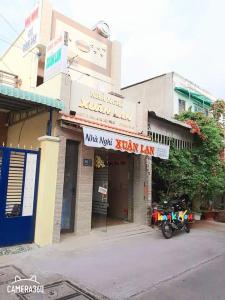 a building with a motorcycle parked in front of it at Nhà Nghỉ Xuân Lan in Ấp An Mỹ