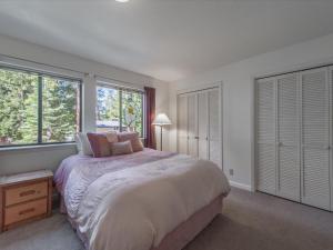 1 dormitorio con 1 cama grande y 2 ventanas en Beaver Street Retreat, en Kings Beach