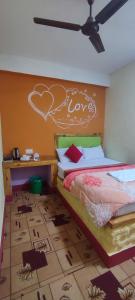 a bedroom with a bed with a heart painted on the wall at Hong Qi Hotel in Chitwan