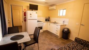 a small kitchen with a table and a refrigerator at Echuca Holiday Units in Echuca
