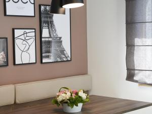 uma sala de estar com um vaso de flores e a torre Eiffel em Studio Aix-les-Bains, 1 pièce, 2 personnes - FR-1-617-26 em Aix-les-Bains