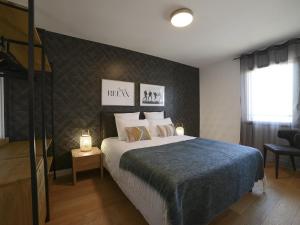- une chambre avec un grand lit et une couverture bleue dans l'établissement Appartement Aix-les-Bains, 2 pièces, 2 personnes - FR-1-617-32, à Aix-les-Bains