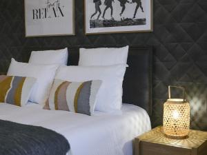 - une chambre avec un lit doté d'oreillers blancs et d'une lampe dans l'établissement Appartement Aix-les-Bains, 2 pièces, 2 personnes - FR-1-617-32, à Aix-les-Bains