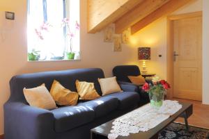 ein Wohnzimmer mit einem blauen Sofa und einem Tisch in der Unterkunft Bella Vista in Canale San Bovo