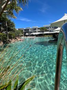 a pool of water with a resort in the background at Cosy Hotel Room with plunge pool at Kingscliff Salt Beach Resort and Spa in Kingscliff