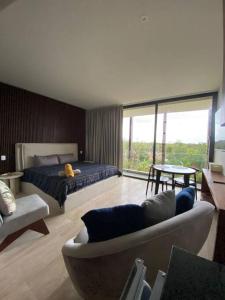 ein Schlafzimmer mit einem Bett, einem Sofa und einem Tisch in der Unterkunft new charming studio with terrace in Tulum