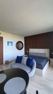 Schlafzimmer mit einem Bett mit blauen Kissen und einem Tisch in der Unterkunft new charming studio with terrace in Tulum