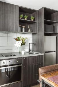 a kitchen with a sink and a counter with flowers at Timber Door Luxury Accommodation Geelong in Geelong