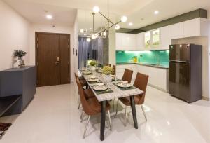 eine Küche und ein Esszimmer mit einem Tisch und Stühlen in der Unterkunft Jessie Saigon Apartment - Vinhome Central Park in Ho-Chi-Minh-Stadt