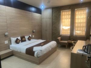 um quarto com uma cama, uma secretária e uma janela em HOTEL RAJMAHAL GREEN em Bhiwadi