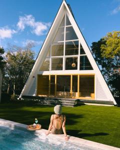 Eine Frau, die in einem Pool mit einem Pyramidenhaus sitzt. in der Unterkunft クラフトホテル瀬戸内 in Higashikagawa