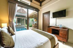 a bedroom with a large bed and a television at ME Villas Echo Beach Canggu in Canggu