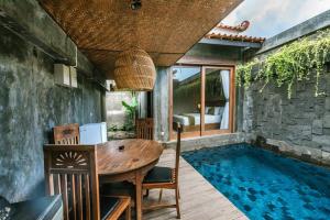 a room with a table and a swimming pool at ME Villas Echo Beach Canggu in Canggu