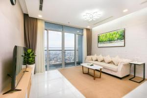 a living room with a couch and a tv at Jessie Saigon Apartment - Vinhome Central Park in Ho Chi Minh City