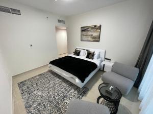 a bedroom with a bed and a couch and a chair at CMA Skyline Sanctuary Apartments - Ajman Corniche UAE in Ajman 