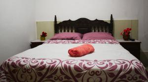Una cama grande con una almohada roja. en Blue Beach House Chicama - Habitaciones, en Puerto Chicama
