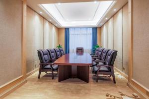 a conference room with a wooden table and chairs at The Skytel Shenzhen Shekou in Shenzhen