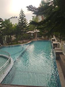 duży basen z drzewami w tle w obiekcie Vila Adinda Syariah C-4 Bukit Gardenia Resort w mieście Garut